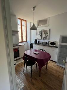 a kitchen with a table in the middle of a room at Chez Marie in Pont-en-Royans