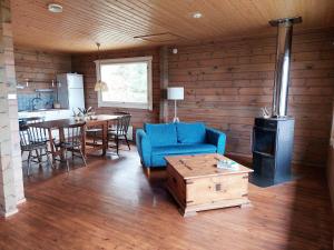 a living room with a blue couch and a stove at Uttis Home in Nauvo