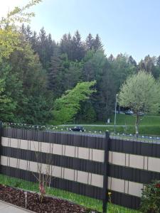 Ein schwarzer Zaun mit einem Park im Hintergrund in der Unterkunft Beutlich's Wörtherseeappartements in Velden am Wörthersee