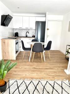 a kitchen with a table and chairs in a room at L'Escapade Bohème - piscine, plages & farniente in La Grande-Motte