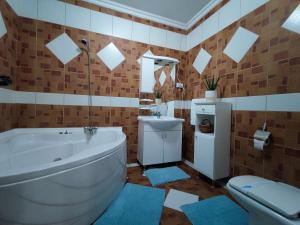 ein Badezimmer mit Badewanne, Toilette und Waschbecken in der Unterkunft Jelen salaš in Palić