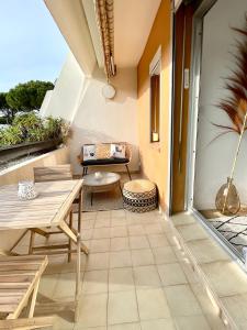 a patio with a table and chairs on a balcony at L'Escapade Bohème - piscine, plages & farniente in La Grande Motte