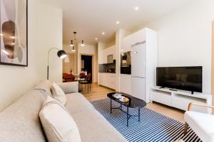 sala de estar con sofá y TV en BARTOLOME Suite Apartment, en San Sebastián
