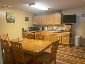 a kitchen with a wooden table and chairs and a kitchen with a television at McKinley View B&B in Trapper Creek