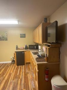 a kitchen with wooden cabinets and a flat screen tv at McKinley View B&B in Trapper Creek