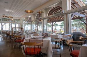 un comedor con mesas, sillas y ventanas en Résidence du Lido, en Argelès-sur-Mer