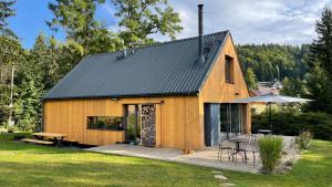 a wooden house with a deck and a table at Chalet Bedřichov in Bedřichov