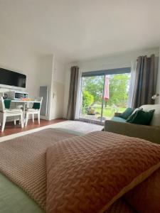 Cottage au sein du "Hameau du golf" de la Bretesche في Missillac: غرفة نوم بها سرير ونافذة كبيرة