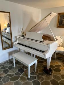 ein weißes Klavier in einem Zimmer mit Spiegel in der Unterkunft Schloss Grabow, Resting Place & a Luxury Piano Collection Resort, Prignitz Brandenburg in Grabow