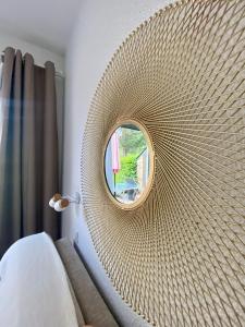 espejo circular en la pared de un dormitorio en Cottage au sein du "Hameau du golf" de la Bretesche, en Missillac