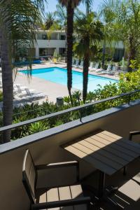 a balcony with a bench and a swimming pool at Lemon Tree Inn in Santa Barbara