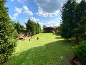 een grote tuin met een bank en een speeltuin bij Domek Nad Jeziorem Piasutno Mazury in Piasutno