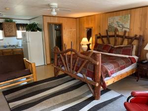 a bedroom with a large wooden bed and a kitchen at Phillips Historic Motel & Cottages in Robbinsville