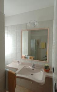a white bathroom with a sink and a mirror at Albergo Castello in Valfurva