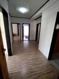 波蘇施耶的住宿－Apartmani Posušje，一间空房间,走廊上铺有木地板