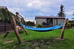 a hammock in a yard with a house at Domek w Otulinie Biebrzy in Goniadz