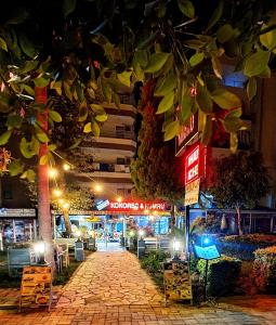 a cobblestone walkway in front of a building at night at Palmen Apart Hotel in Alanya
