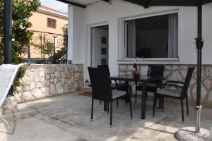 a patio with a table and chairs and a window at Apartman Vitamare 160 m from the beach in Novi Vinodolski +31 photos