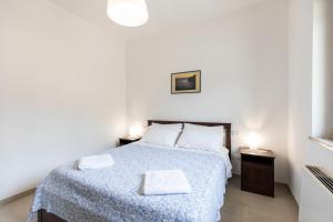 a bedroom with a large bed with a blue blanket at Villa Alice in Capo Vaticano