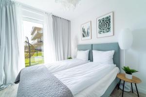 Posteľ alebo postele v izbe v ubytovaní ApartView - ogród, taras, winda, widok na Jeziorak, Netflix i Max, parking