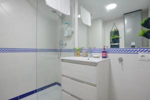baño blanco con ducha y lavamanos en Almansa Malaga Center, en Málaga