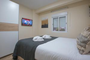1 dormitorio con 1 cama con 2 toallas en Almansa Malaga Center, en Málaga