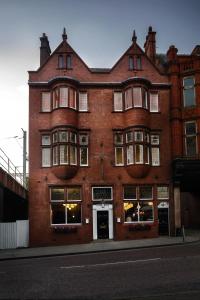 a large red brick building on a city street at Swan & Railway Hotel Wigan in Wigan