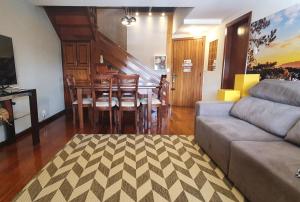 a living room with a couch and a table and chairs at Apto Centro de Gramado com Praticidade e Conforto in Gramado