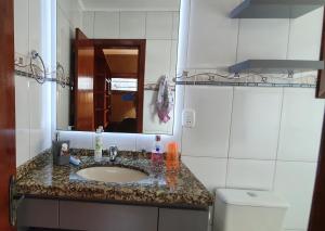a bathroom with a sink and a mirror and a toilet at Apto Centro de Gramado com Praticidade e Conforto in Gramado +8 photos