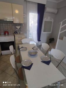 een keuken met een tafel en stoelen met kommen en borden erop bij KALLITHEA Nastro Azzurro in Kallithea