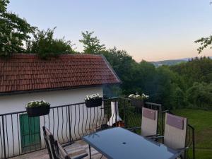 a table and chairs on a balcony with a view of a house at Ravne Rest House in Visoko