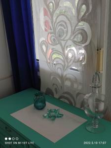 einen Tisch mit einer Glasvase und einer Blume darauf in der Unterkunft KALLITHEA Nastro Azzurro in Kallithea (Chalkidiki)