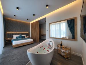 a bathroom with a tub and a bedroom with a bed at Hotel Excellence in Bucharest