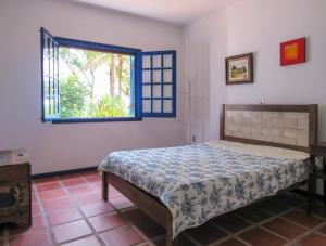 1 dormitorio con cama y ventana en Casa de campo c Churrasq e Piscina, Porto Feliz SP en Pôrto Feliz