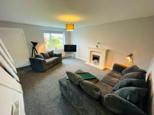 a living room with a couch and a fireplace at Newly refurbished 3 bedroom house in Heysham