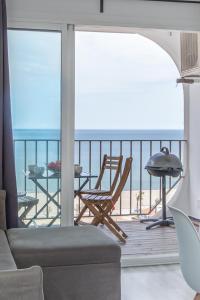 a living room with a balcony with a view of the ocean at BLUE HOLIDAYS RELAX & VIEWS Sylvia12 in Empuriabrava