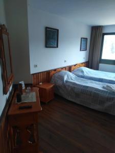 a hotel room with two beds and a table at Вила Родопи in Dospat