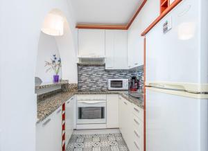 a kitchen with white cabinets and a tile floor at BLUE HOLIDAYS RELAX & VIEWS Sylvia12 in Empuriabrava