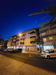 een gebouw waar 's nachts auto's voor geparkeerd staan bij Apartamento céntrico en Candelaria, con piscina. in Santa Cruz de Tenerife