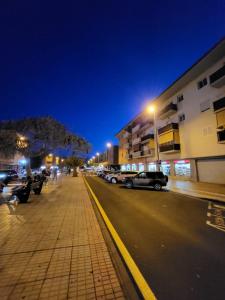 a city street at night with cars parked on the street at Apartamento céntrico en Candelaria, con piscina. in Santa Cruz de Tenerife