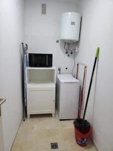 a small kitchen with a microwave and a refrigerator at Apartamento céntrico en Candelaria, con piscina. in Santa Cruz de Tenerife