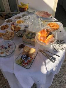 una mesa blanca con un montón de comida. en B&B Relais dell'Angelo en Camaiore