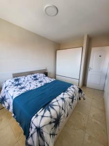 een slaapkamer met een bed met een blauwe deken bij Apartamento céntrico en Candelaria, con piscina. in Santa Cruz de Tenerife