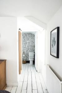 een hal met een toilet in een witte badkamer bij Cute Self Catering Flat in the Brecon Beacons in Crickhowell