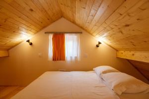 Bett in einem Zimmer mit Holzdecke in der Unterkunft Villa M in Vinci