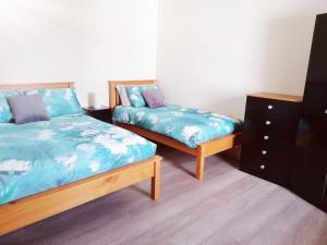 a bedroom with two beds and a dresser at Cosy 2 Bedroom Cottage in Laconnell