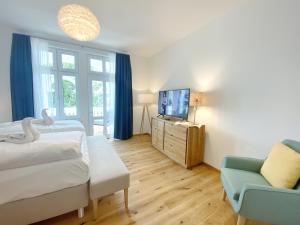 1 dormitorio con 2 camas, TV y sofá en Villa Jenny Sassnitz Villa Jenny - Appartement 3, en Sassnitz