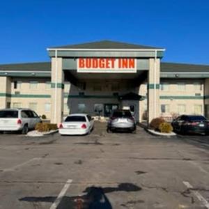 a building with cars parked in a parking lot at Budget Inn Wentzville in Wentzville