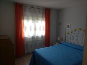1 dormitorio con 1 cama y una ventana con cortinas rojas en Chalet adosado con jardín, en Cebreros