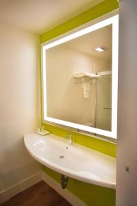 La salle de bains est pourvue d'un lavabo et d'un grand miroir. dans l'établissement Foothills Motel, à Auburn